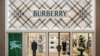 Burberry store facade with classic plaid pattern, logo, display windows featuring mannequins and handbags