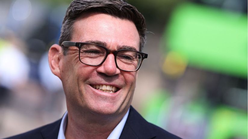Andy Burnham, Mayor of Greater Manchester, smiling and wearing glasses outdoors.