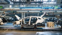 Car bodies on an assembly line in a UK car plant, showcasing EV manufacturing process