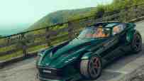 Dark green Donkervoort sportscar with exposed front wheels and orange interior, parked on a winding road with mountains