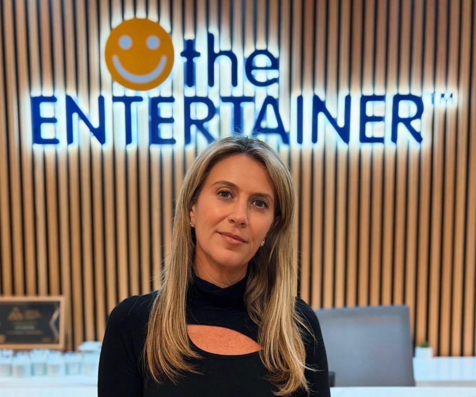 Donna presenting at the Entertainer conference, engaging with audience during a business seminar, wearing a professional o...