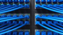 Close-up of vibrant fibre optic cables with glowing blue and green lights, symbolizing fast internet connectivity and data...