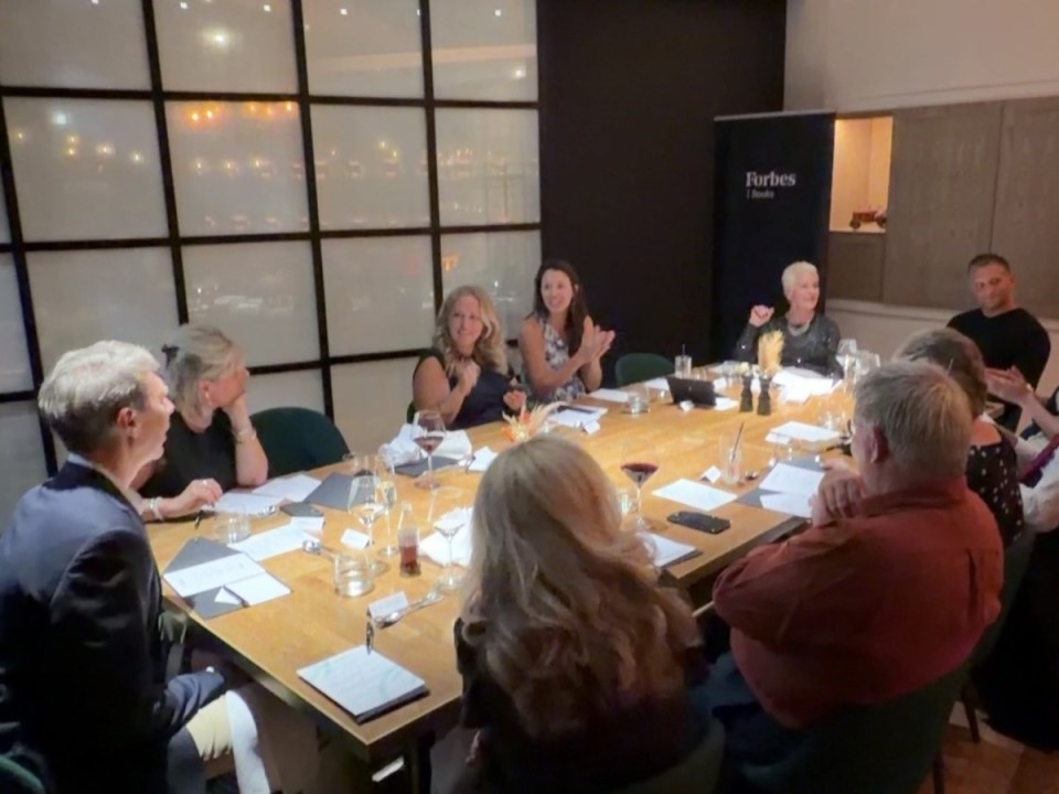 Attendees at a Forbes dinner, including business professionals, seated around a large table in a restaurant.