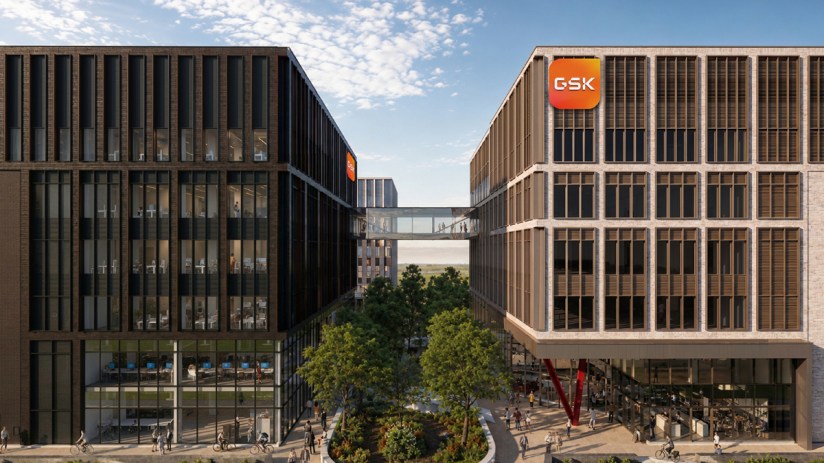 Modern GSK Cambridge campus buildings with sky bridge, green spaces, and people walking and cycling.