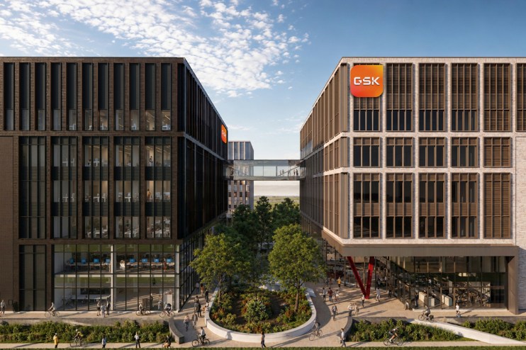 Modern GSK Cambridge campus buildings with sky bridge, green spaces, and people walking and cycling.