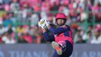 Young cricket player in pink and blue uniform with Rajasthan Royals helmet batting during a match.