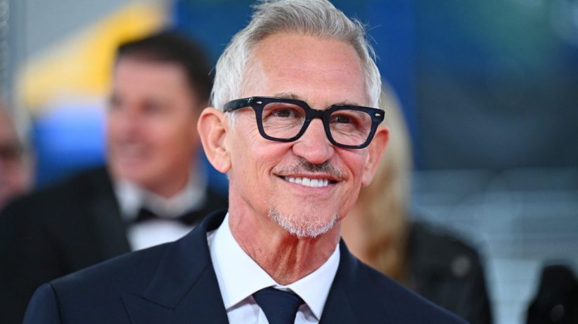 Gary Lineker in a suit and tie, smiling with glasses and a goatee, against a blurred background.