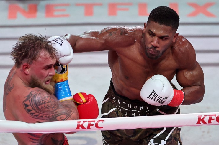 Anthony Joshua landing a punch on Jake Paul during a boxing match