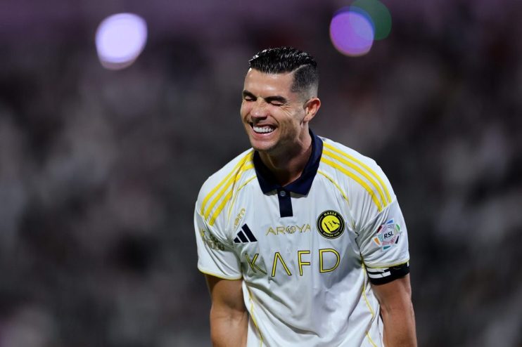 Cristiano Ronaldo smiling in his white and yellow Al Nassr football jersey during a match
