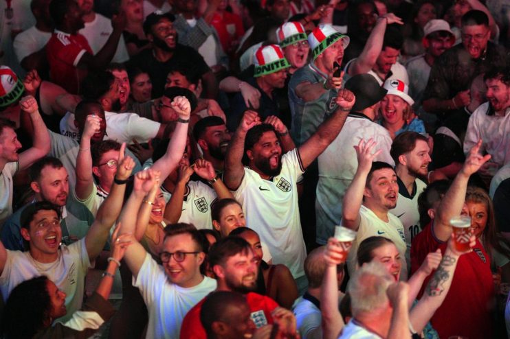 Brits celebrating in a pub, raising pints during England vs Mexico World Cup match, highlighting hospitality boost