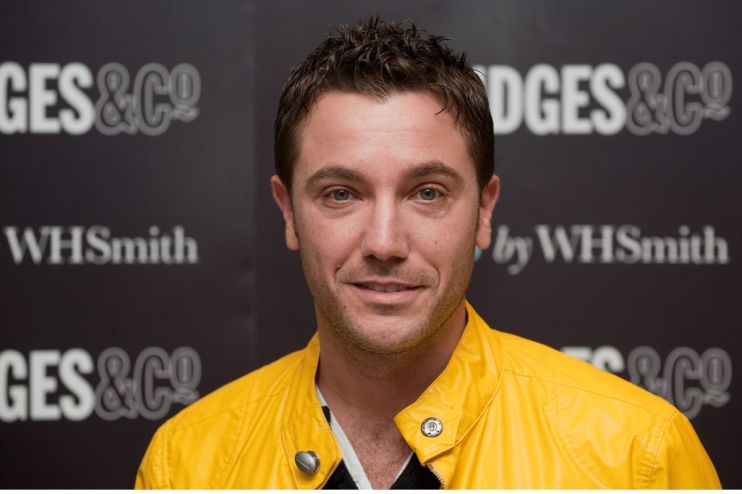 Gino DAcampo, smiling in a bright yellow jacket, against a dark background with GES & CO and WHSmith logos