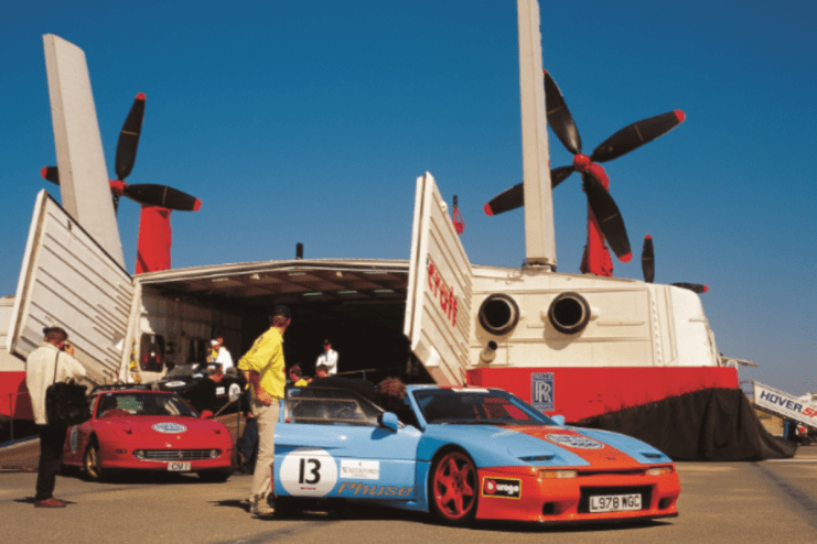 Luxury sports cars lined up at the start of the Gumball 3000 rally, showcasing sleek designs and vibrant colors.