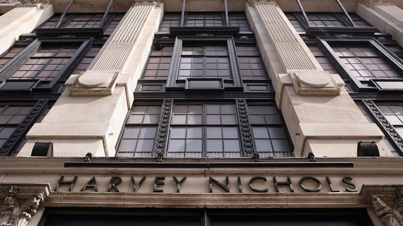 Harvey Nichols storefront featuring elegant window displays and seasonal decorations in a bustling city setting