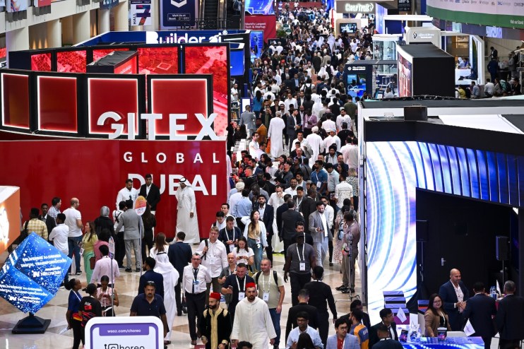 Crowd of diverse attendees at GITEX GLOBAL DUBAI tech exhibition, with GITEX signage visible.