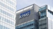 KPMG office building exterior with company logo under clear blue sky, representing global professional services firm