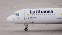 Lufthansa aircraft on tarmac with logo visible, showcasing airlines fleet under clear sky in a business news context