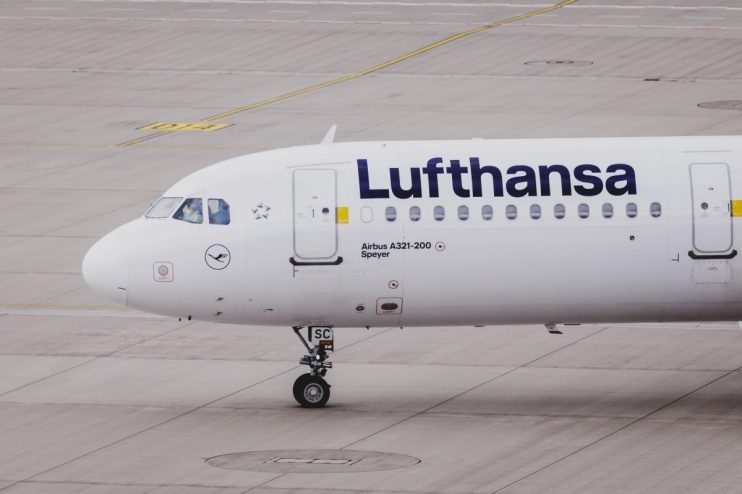 Lufthansa aircraft on tarmac with logo visible, showcasing airlines fleet under clear sky in a business news context