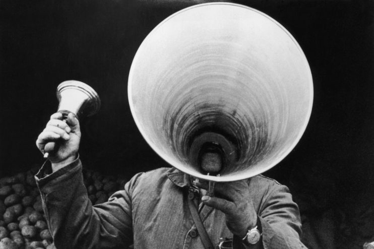 Person holding a megaphone, emphasizing a key announcement in a general news article on a business website.