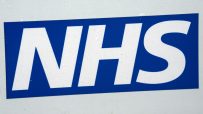 NHS logo on a white surface with visible water droplets, blue and white branding