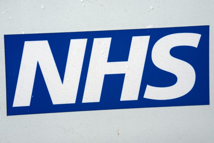 NHS logo on a white surface with visible water droplets, blue and white branding