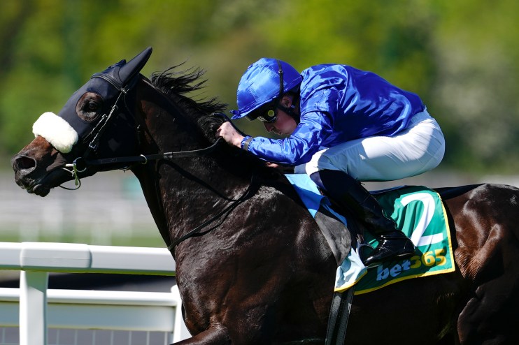Racehorse Opera Ballo and jockey in blue silks galloping during a race on a sunny day