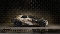 Range Rover GT side profile in camouflage wrap, parked in an anechoic chamber for acoustic testing.