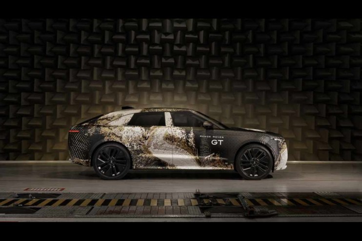 Range Rover GT side profile in camouflage wrap, parked in an anechoic chamber for acoustic testing.