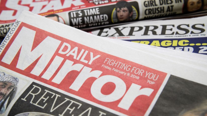 Stack of newspapers including Daily Mirror, Daily Express, and Daily Star, showcasing headlines and mastheads.