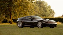 Ferrari Daytona Hommage sports car in vibrant red, showcasing sleek design and iconic style, parked on a scenic road.