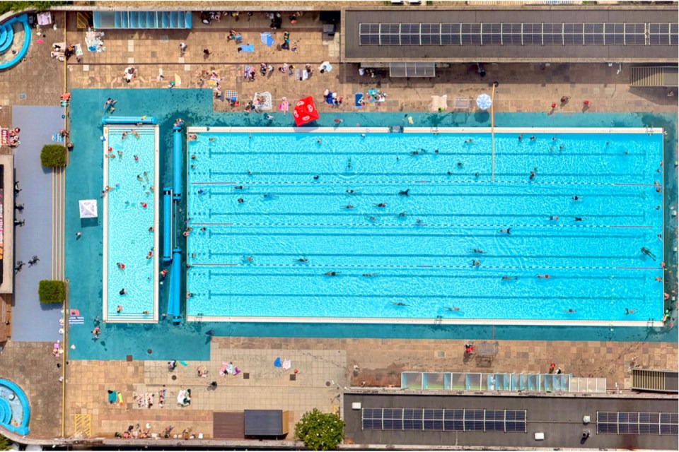 Goodyear blimp hovering over a luxurious pool, capturing a unique aerial view for a special event coverage