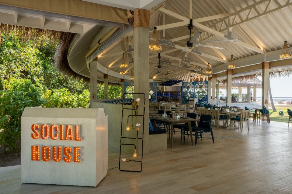 Interior of Maldives Ifuru Social House, an open-air restaurant with a Social House sign and tropical views.