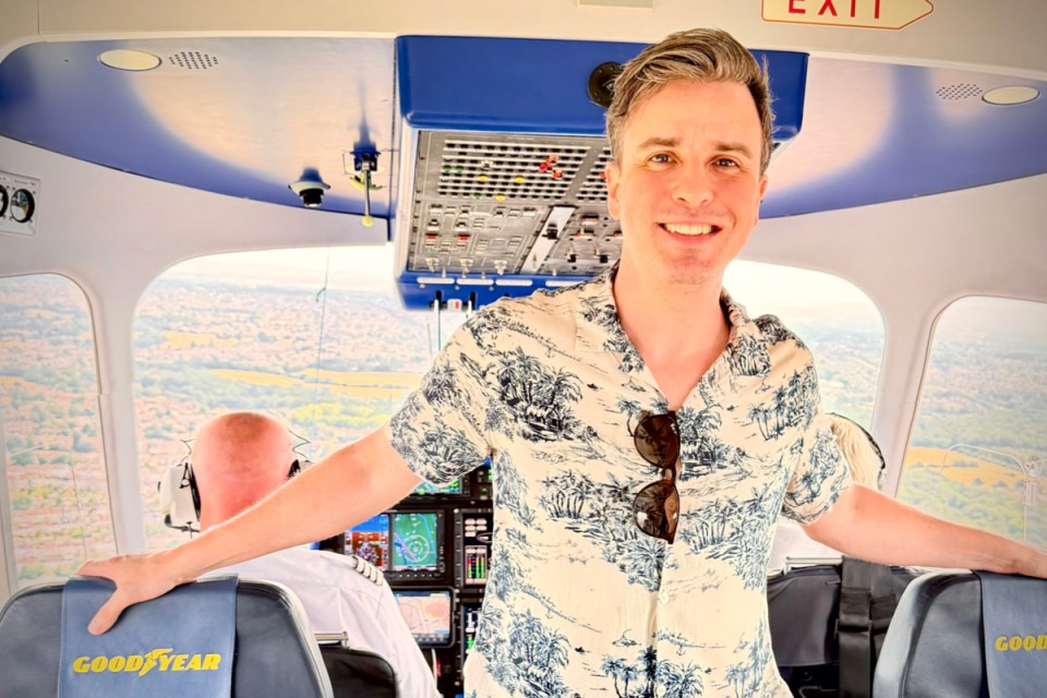 Person inside a blimp gondola overlooking cityscape, showcasing aerial view and modern aviation technology.