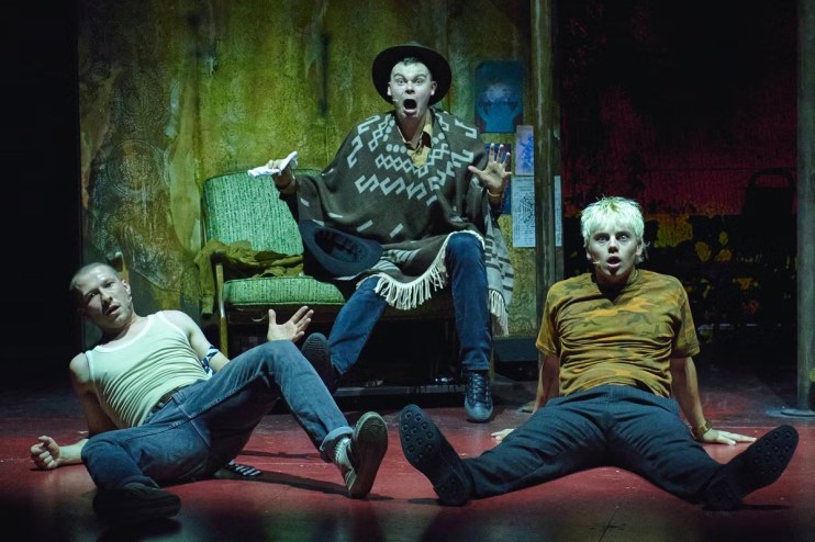 Three actors in distressed clothing on a stage, portraying characters from Trainspotting The Musical.