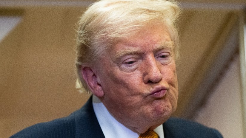 Donald Trump delivering a speech at a podium during a formal event, emphasizing key points to an attentive audience.