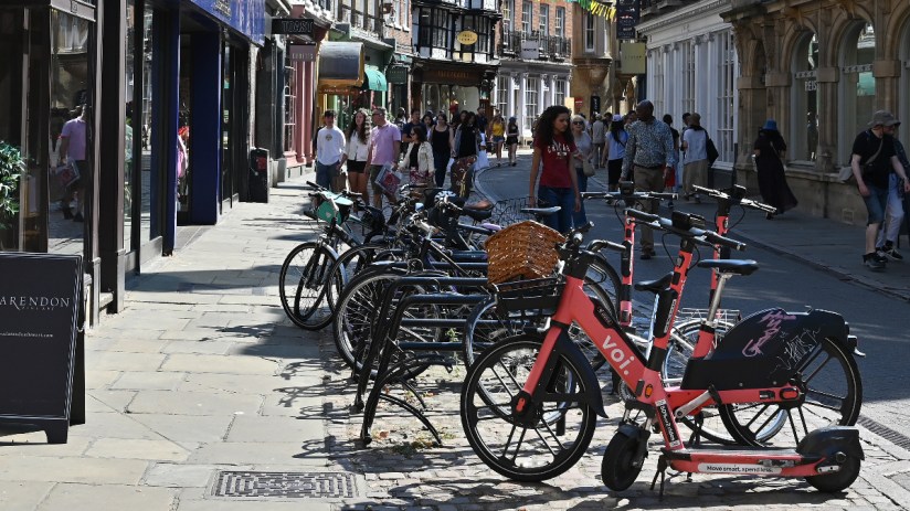 Voi electric scooters lined up on a city street, highlighting urban mobility solutions and eco-friendly transportation opt...