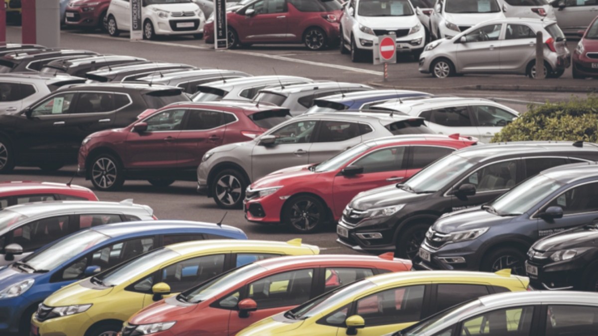 Rows of new and used cars parked at a dealership lot, ready for sale.