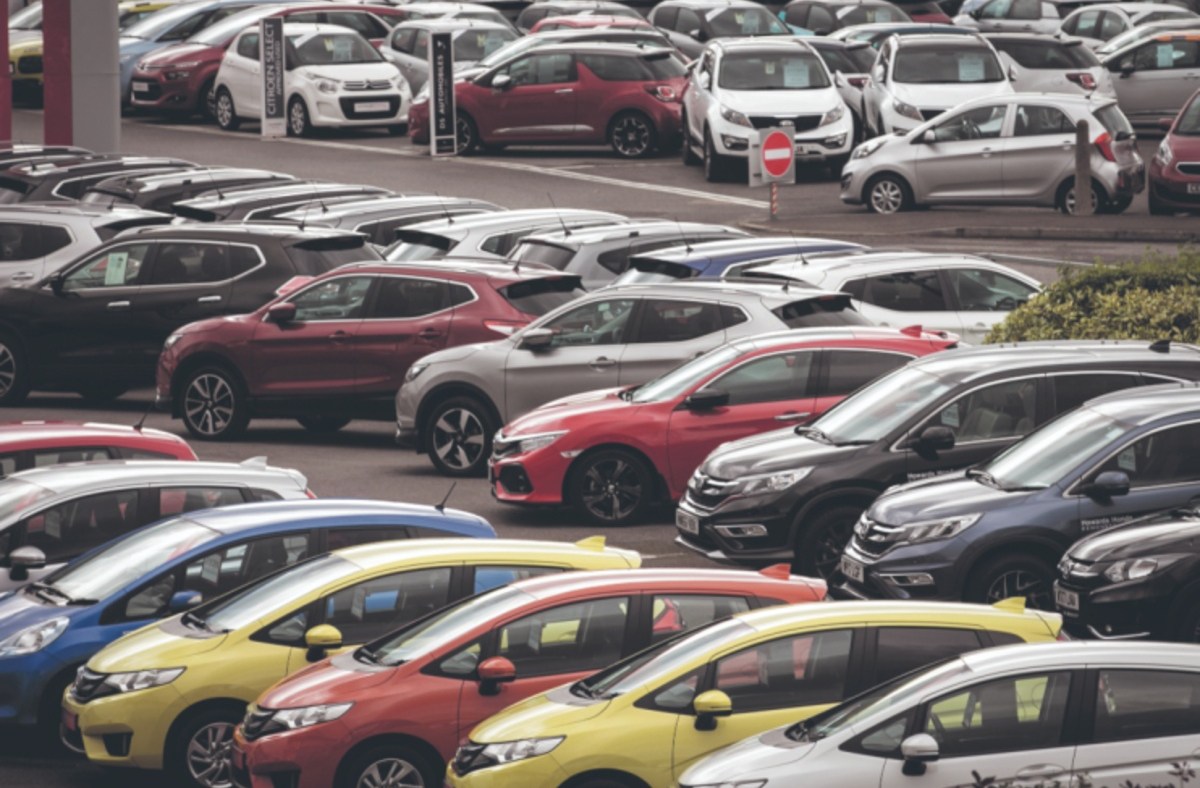 Rows of new and used cars parked at a dealership lot, ready for sale.