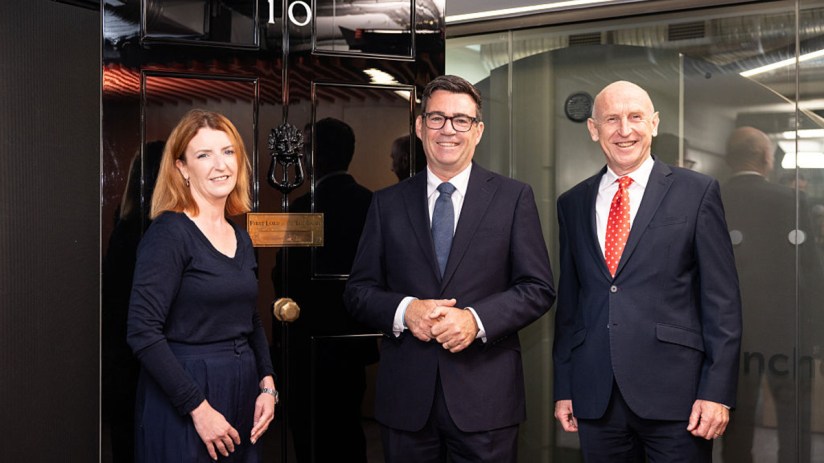 Andy Burnham, John Healey, and Louise Haigh by a doorway, discussing tax policy for a news article.