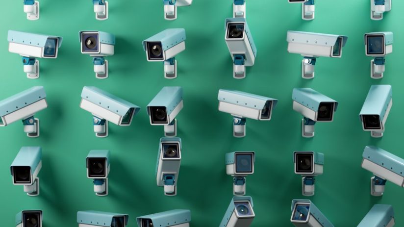 Multiple CCTV security cameras in light blue and white against a green background, emphasizing surveillance and monitoring.