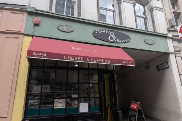Exterior of Cheese & Peppers cafe at 11 Talbot Court, featuring a red awning and storefront.