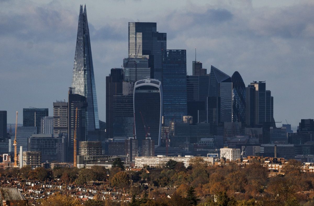 London skyline with The Shard, Walkie Talkie, and Gherkin skyscrapers towering over residential buildings and autumn trees.