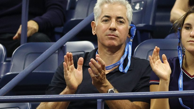 Bill Ackman, CEO of Pershing Square, clapping at the US Open, wearing an American Express lanyard.