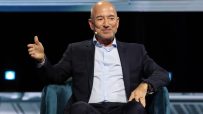 Jeff Bezos, Amazon founder, in a blue suit and light shirt, speaking at a business event