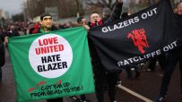 Football fans protest holding Love United Hate Glazer and Glazers Out Ratcliffe Out banners.