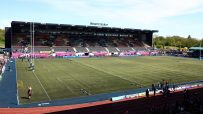 StoneX Stadium, home of Saracens Rugby Club, with empty seats in the stands and a clear green field.
