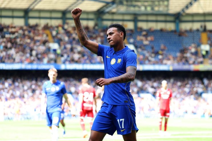 A Chelsea FC footballer in a blue kit with number 17, arm raised in celebration on the field.