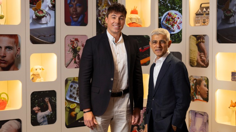Gregory Owens and Sadiq Khan, London Mayor, stand smiling in a gallery with various framed images.