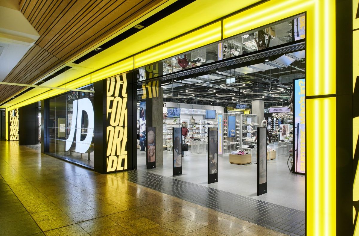 Brightly lit JD Sports store entrance at Meadowhall, showcasing footwear and apparel displays