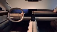 Futuristic interior of a Jaguar car, featuring a minimalist dashboard, white steering wheel, and a sleek central console d...