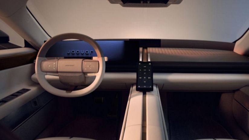 Futuristic interior of a Jaguar car, featuring a minimalist dashboard, white steering wheel, and a sleek central console d...